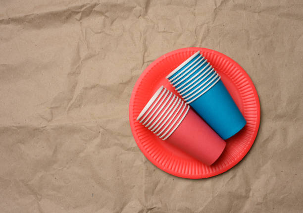 pila di tazze di carta e piatti rotondi su uno sfondo di carta marrone - disposable cup cup stack blue foto e immagini stock