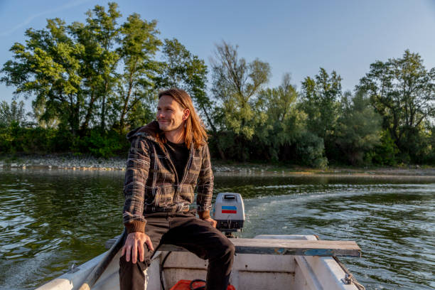 istock Chilled and pensive man riding boat on river 1311629213