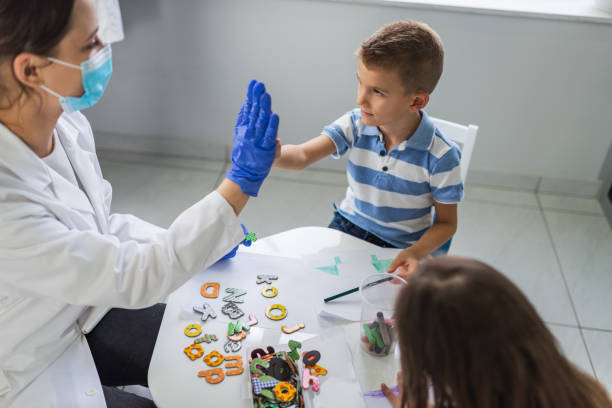 kinder im logopädenbüro - nurse high five mask stock-fotos und bilder