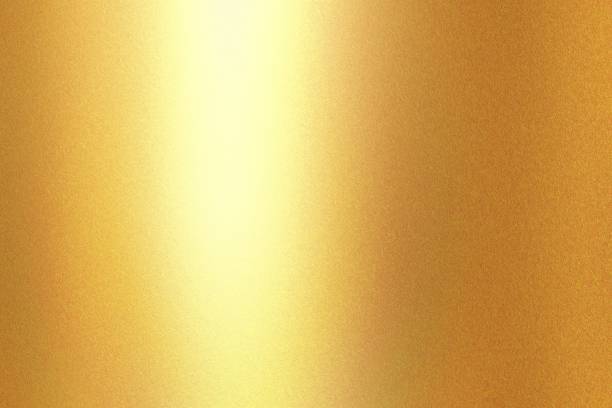 istock Light shining on gold painted metal wall with copy space, abstract texture background 1311631600