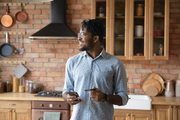istock Young black man ordering food online using phone bank card 1311634279