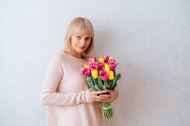 istock Beautiful mature woman holding tulips 1311635366