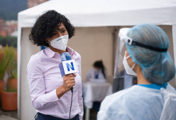 istock Journalist interviewing a healthcare worker working at a COVID-19 vaccination stand 1311635513