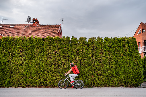 Delivery man riding a bike in street.