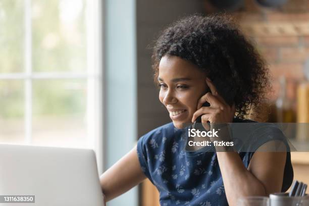 Biracial Female Hold Cell At Ear Look At Pc Screen Stock Photo - Download Image Now - Using Phone, Women, Telephone
