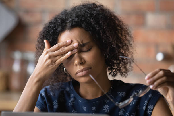 Frustrated black female freelancer overworked by computer feel headache migraine Frustrated black female freelancer overworked by computer feel headache migraine take off eyewear rub nose bridge. Exhausted tired young biracial lady suffer of eye pain vision problem chronic fatigue dizzy spell stock pictures, royalty-free photos & images