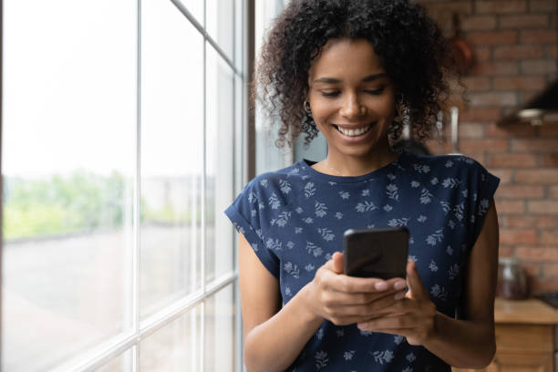 istock Happy mixed race female teenager browsing web on cell 1311638387