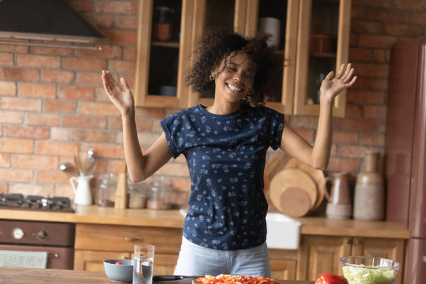 istock Laughing young black female enjoy preparing food dancing having fun 1311638389