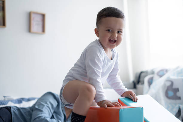 2-year-old baby playing with her mother in bed while playing with educational blocks