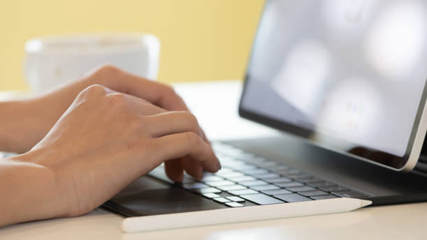 istock Close up of hand and fingers typing or  working with digital tablet or laptop computer. 1311639559