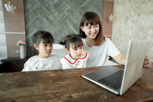 istock Social teleconferencing, Asian daughters and single mothers take online classes Via a computer with a wireless internet system. 1311641440