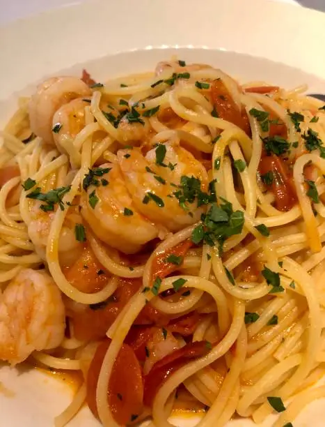 Delicious spagetthi with prawns, tomato sauce and herbs