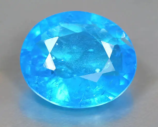 Natural gemstone blue neon apatite on background