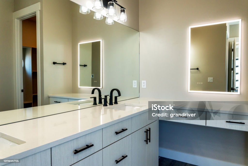 Contemporary Style Well Lit Bathroom With Sinks, Cabinets And Lighted Vanity Mirror Contemporary Style Well Lit Bathroom With Sinks, Cabinets, And Lighted Vanity Mirror Vanity Mirror Stock Photo