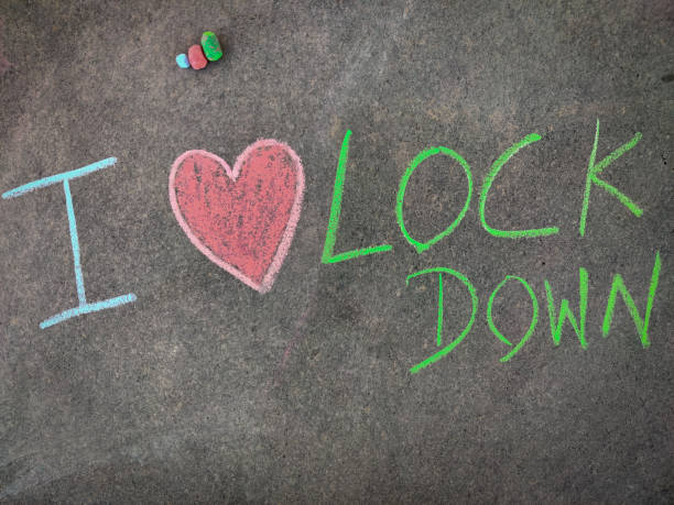 istock The inscription text on the grey board, I lockdown with hand drawn love symbol. (I love lockdown). Using color chalk pieces. 1311644935