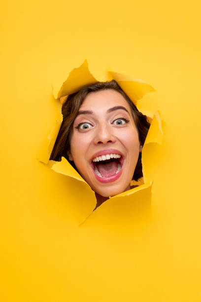 istock Excited woman screaming from hole in paper 1311645720