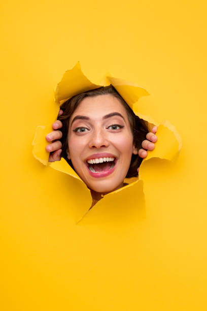 istock Excited woman looking through hole in paper 1311645727