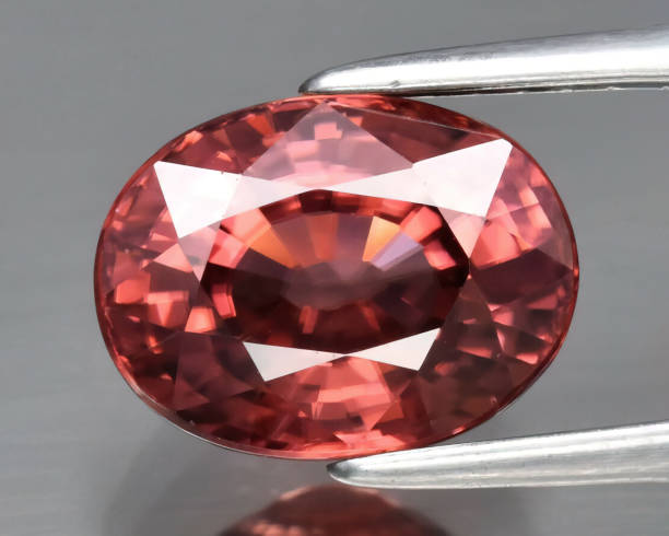 Natural gemstone red zircon on gray background