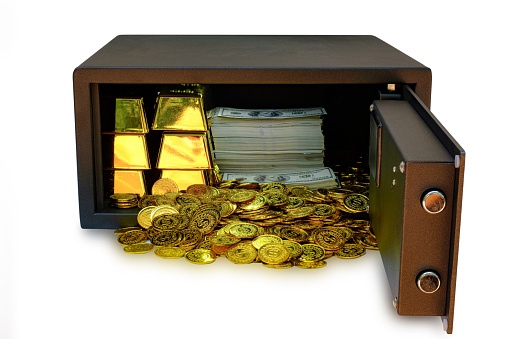 Steel safes box full of coins stack and gold bar and banknote 100 USD at the white background with clipping path, business banking concept