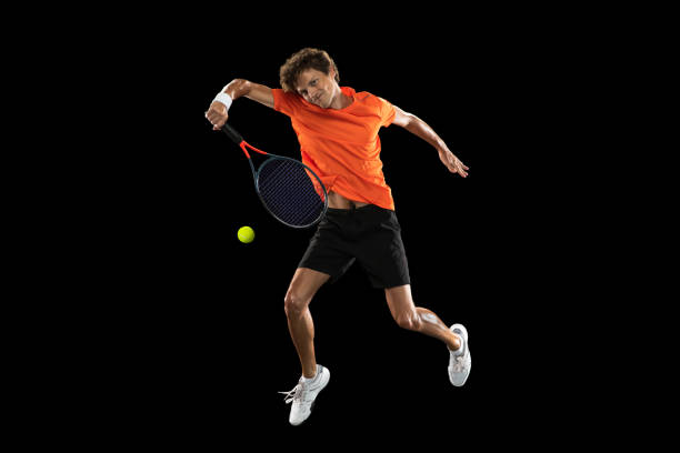 istock Young Caucasian man, tennis player training isolated on black background. 1311649972