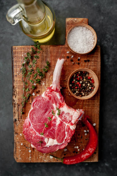 istock raw beef steak, beef tomahawk with spices, thyme on a stone background. with copy space for your text 1311650949