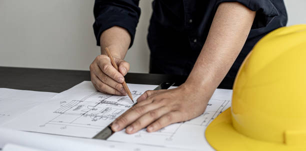 가정 설계 엔지니어인 건축가가 사무실에서 고객을 위한 주택 계획을 작성하고 있습니다. 그는 고객의 요구에 따라 집 계획을 작성하고 있습니다. 집 건물 및 인테리어 아이디어. - engineering drafting plan drawing 뉴스 사진 이미지