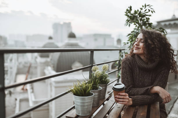 istock Day Dreaming Female Enjoying Takeaway Coffee On Building Rooftop 1311653171