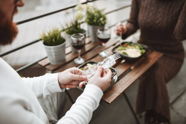 Male Pulling Out Disposable Fork For Salad Dinner And Wine With Girlfriend Male Pulling Out Disposable Fork For Salad Dinner And Wine With Girlfriend caesar salad food salad tuna stock pictures, royalty-free photos & images