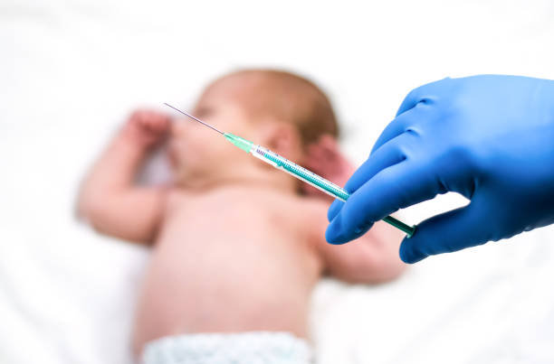 Pediatrician vaccinating newborn baby. Vaccine, Vaccination for infant child Soft focus Syringe in hands of a nurse and blurred background of infant baby on white. Doctor in blue gloves close up. Pediatrician vaccinating newborn baby. Vaccine, Vaccination for infant child Soft focus Syringe in hands of a nurse and blurred background of infant baby on white. Doctor in blue gloves, close up. anti vaccination photos stock pictures, royalty-free photos & images