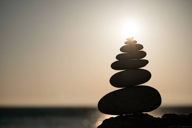 istock Balanced rock pyramid on the pebble beach on sunset. Selective focus Abstract bokeh with Sea on the background. Zen stones on the sea beach, meditation, spa, harmony, calmness, balance concept 1311661752