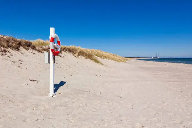 Lifeblet at the beach of Grenaa, Djursland peninsula, Jutland, Denmark. Harbor in background.