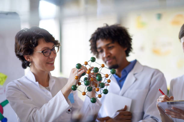 istock Young colleagues learning about chemical bonds on a model in the university laboratory. Science, chemistry, lab, people 1311665760