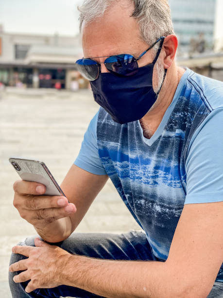 istock Adult man using a smart phone app outdoors during Covid19 crisis 1311667680