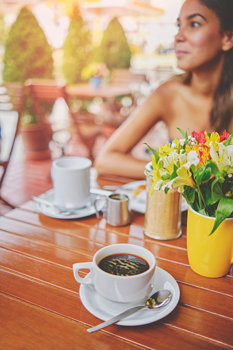 Couple sharing in a cafeteria at sunset, romantic moment with flowers, coffee and vintage site