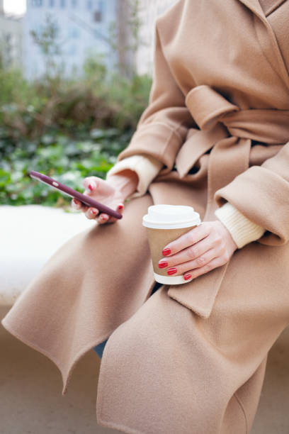 istock Business woman is drinking coffee on the street while having break. 1311671991