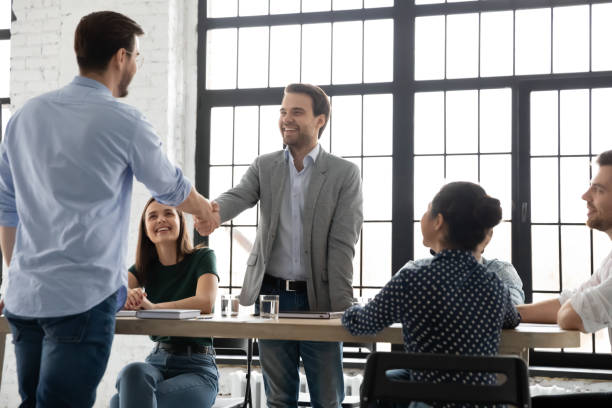 istock Boss handshaking with happy young male worker greeting with promotion 1311672619