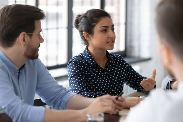 istock Young indian female employee talking to colleagues at workshop 1311672636
