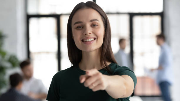 istock Motivated woman intern posing in office pointing finger at camera 1311672657
