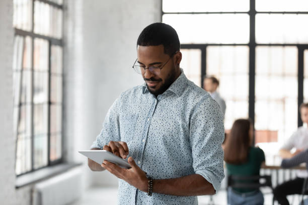 istock Busy black manager standing at office focused on tablet screen 1311672663
