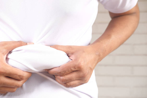 istock man's hand holding excessive belly fat, overweight concept 1311674258