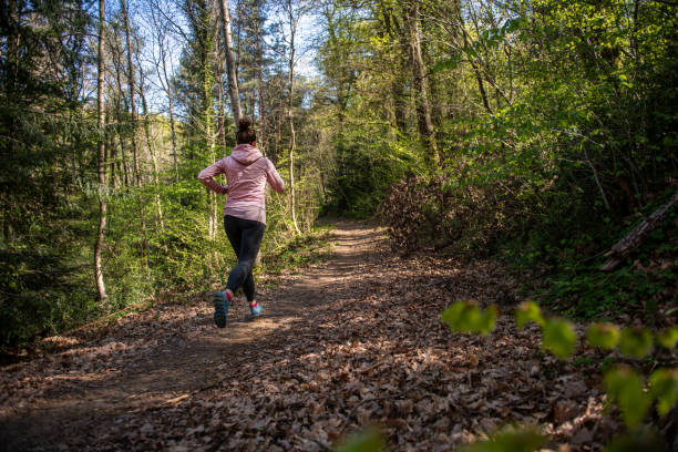 istock Woman running in the Forest Rear view 1311678294