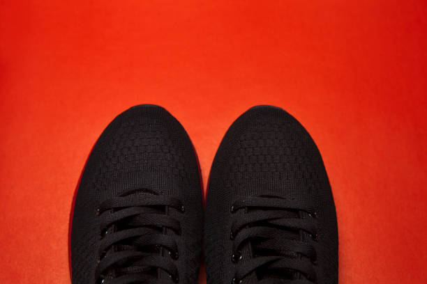 istock Sport black sneakers isolated on red background 1311682460