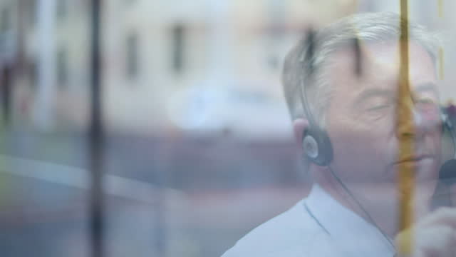 Animation of road traffic over man with headset talking, working in warehouse shipping centre