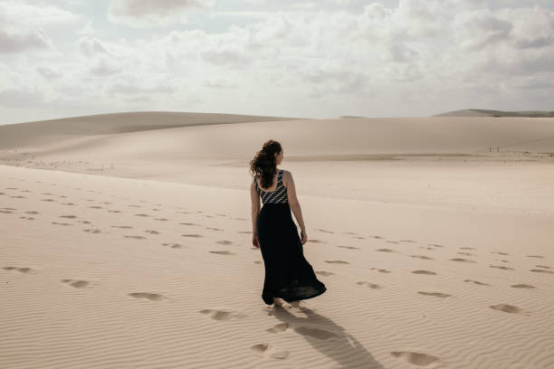 istock Woman walking on the sand 1311683513