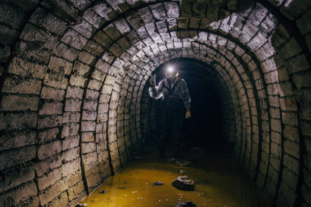 homem em traje de proteção dentro de mina de urânio abandonada - flashlight cave spelunking explorer - fotografias e filmes do acervo