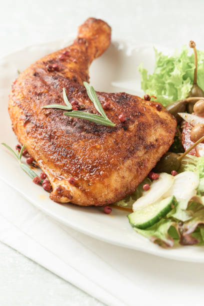 istock Spicy chicken leg with fresh salad on bright background. Close up. 1311684228