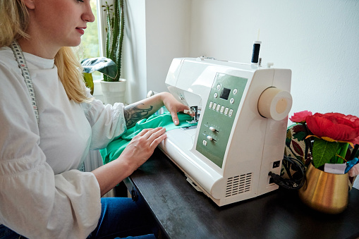 Shot of a fashion designer using a sewing machine in her workshop