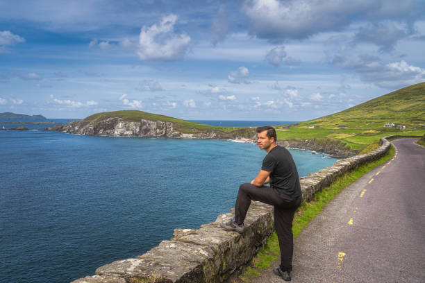 homem de meia-idade observando e admirando uma vista incrível de slea head e península dingle - republic of ireland famous place dingle peninsula slea head - fotografias e filmes do acervo