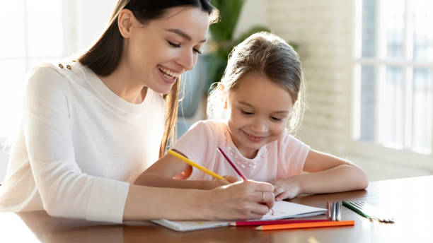 istock Happy young mom and little daughter draw together 1311686834