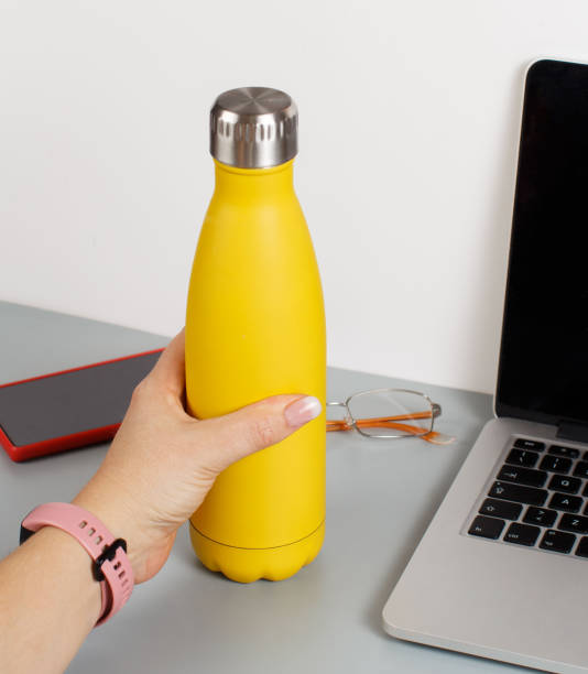 istock Hand takes yellow insulated bottle 1311687067